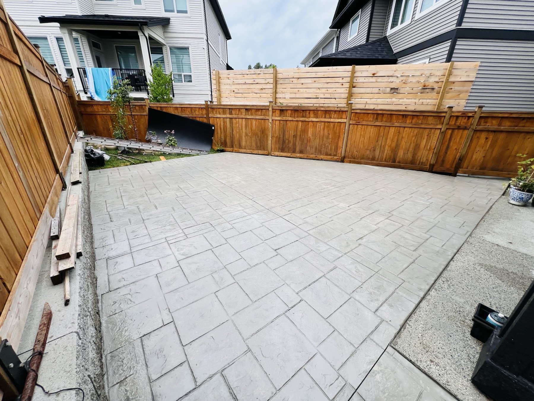 Stamped concrete pathway running beside a cedar fence